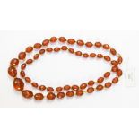 A faceted amber type bead necklace with a yellow metal clasp,