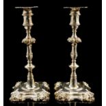 A pair of George II/III cast silver candlesticks,