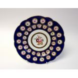 A Derby Bloor dessert plate, circa 1825, decorated with roses within gilt wreaths, on a blue ground,