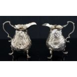 Two George III silver cream jugs, baluster form on three shell and scroll trefoil feet,