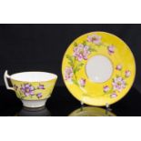 A Derby King Street teacup and saucer, yellow ground, painted by J Wencker, with dog roses,