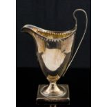 A George III silver cream jug, pedestal Neoclassical helmet form, on square base,