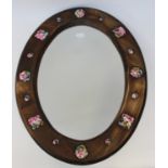 An Arts and Crafts beech and enamel framed mirror,