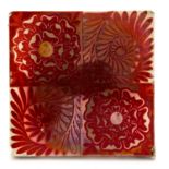 William De Morgan, a red lustre tile, quartered into alternating Tudor rose and foliate spirals,