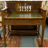 An Arts and Crafts oak writing desk, with a pierced and slatted back,