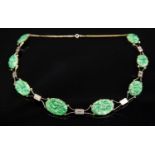 An Art Deco Chinese jade and white metal (gold) necklace, the carved plaques linked by bars,