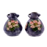 Two Watcombe, Torquay ware bulbous twin handled vases, circa 1900, purple ground,