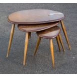 An Ercol dark elm and beech nest of three pebble tables,