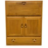 An Ercol Windsor light elm bureau cabinet, the fall front over double door cupboard and draw below,