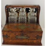 An early 20th cent oak Tantalus and Games Compendium, with applied brass decoration, including three