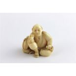 A Japanese Meiji period Ivory netsuke of a seated man smoking pipe, late 19th century, having