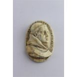 An antique Northern European relief carved ivory cameo of a monk, having inscription to border,