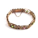 A 9ct. gold bracelet, set alternatively peridot and pink stones, stamped 9 ct. (Approx. 15.8 g)