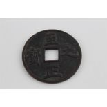 A large antique Chinese bronze coin, having characteristic square hole to centre and raised