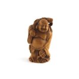 A Japanese Taisho period boxwood netsuke, early 20th century, fashioned as a standing fat bellied