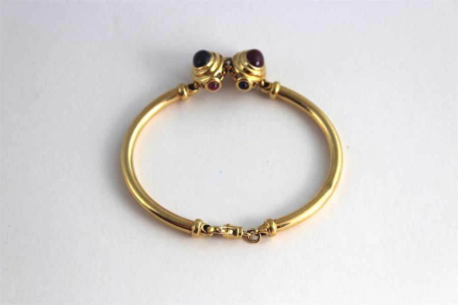 An 18ct gold bracelet set with sapphire and ruby cabochons, having twin stepped oval gold mounts, - Image 2 of 3