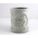 A Chinese Blanc de Chine brush pot with character mark to base, with applied dragon design.height