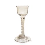 An 18th century opaque twist wine glass, the ogee bowl on a ribbon and lattice corkscrew core stem,