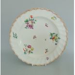 A Chelsea Derby porcelain plate with a fluted rim border, painted with cut fruit,