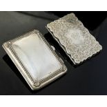 An Edwardian silver rectangular aide memoire, the body chased with gadroon and shell border,