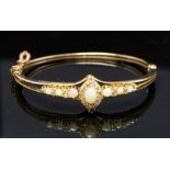 An Edwardian opal and diamond cluster yellow gold bangle, with opal and diamond set shoulders,