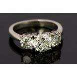 A diamond three stone platinum ring, comprising three round brilliant cut diamonds,