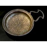 A George III silver lemon strainer, circular pierced body with gadroon rim, double scroll handle,