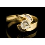 A diamond single stone yellow gold ring with diamond set cross over shoulders,