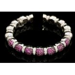 A ruby and diamond set 18ct white gold torque bangle, bead design links, the front section pave set,