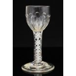 An 18th century opaque twist wine glass, the rounded bowl with moulded fluting,