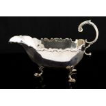 A George V silver sauce boat fluted body, with shaped rim on splayed feet, C-scroll handle, Chester,