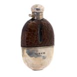 A late Victorian silver mounted hip flask, oval shaped with crocodile leather cover,