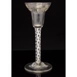 An 18th century opaque twist wine glass, the pan top bowl engraved with a band of fruiting vines,
