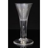 An 18th century wine glass, the trumpet bowl on plain stem with teardrop inclusion, on conical foot,