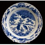 A Chinese blue and white dish painted in the centre with deer and crane below a pine tree,