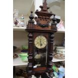 A 19th Century Vienna style wall clock with key and pendulum,