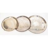 A circular silver plated tray with chased design;