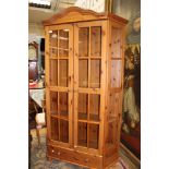 A contemporary pine two door glazed bookcase,