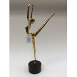 A brass ballerina, mounted on ebonised wooden support,