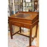 An early 20th century oak clerks desk, the fall front with a leather inset surface,