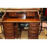 An early 20th Century mahogany roll top tambour desk, 116cm high, 135cm wide,