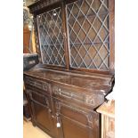 A Jacobean style oak glazed bookcase, the upper section with lead glazed doors,