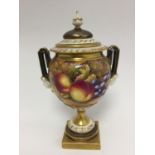 A Royal Worcester fruit painted pedestal vase, having twin handles with mask decoration and cover,