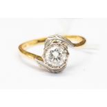 A diamond solitaire 18ct gold ring, with cross over shoulders,