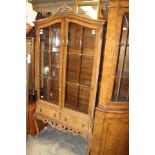 A Georgian style walnut display cabinet, fitted with two glazed doors over two drawers,