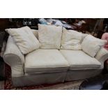 A contemporary cream upholstered two seater settee