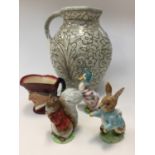 A Charlotte Rhead jug a/f, together with three Beatrix Potter figures s/d,