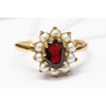 A 9ct gold, pearl and garnet cluster ring, central oval garnet with a pearl surround, size Q1/2,