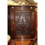 An early 20th Century oak corner cupboard,