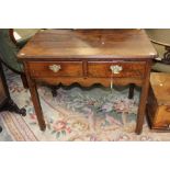 A George III oak side table, fitted with two drawers,